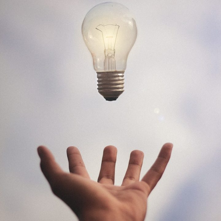 A lightbulb floating over an outstretched hand